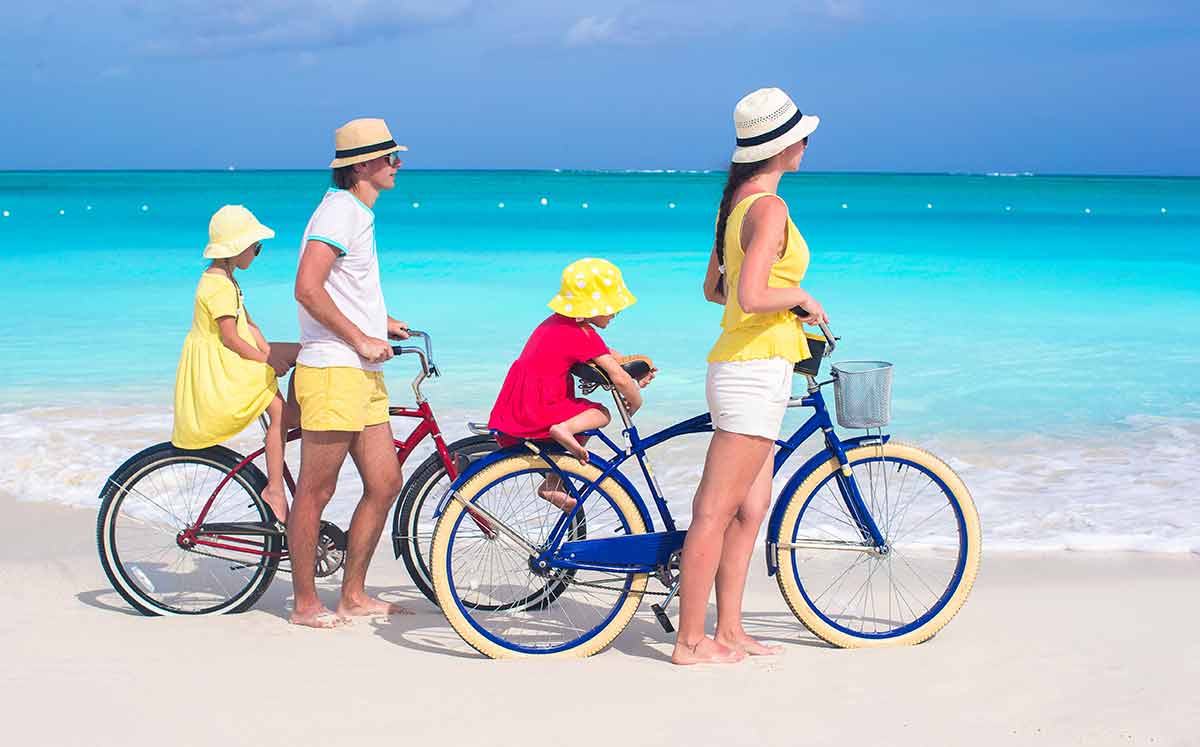 best beaches in turks and caicos two bikes, man and woman with two kids on the beac