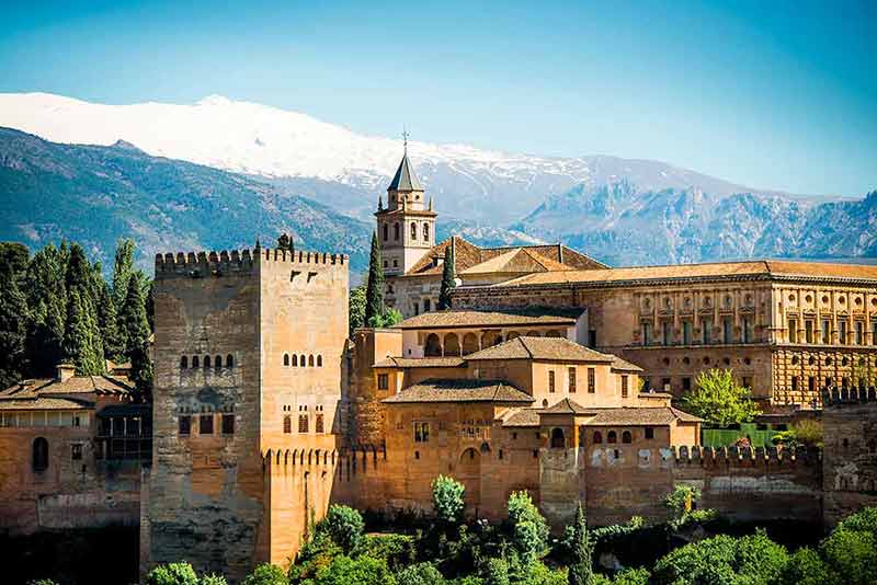 best cities in spain view of alhambra with snow-covered mountains in the background