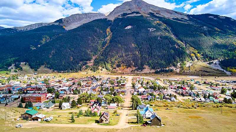 Aerial View Of Rural Mining Town Of Silverton In Colorado Against Wall Of Mountains