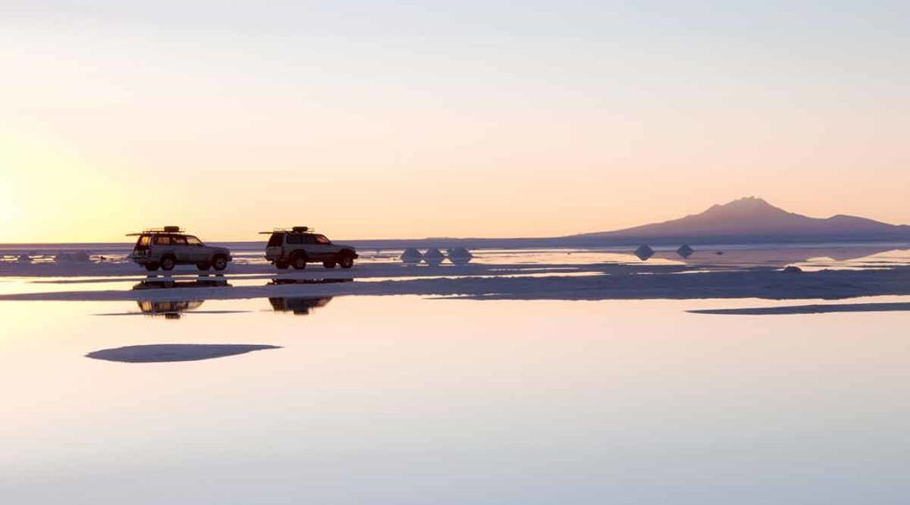 Vehicles reflected in Bolivia's salt flats