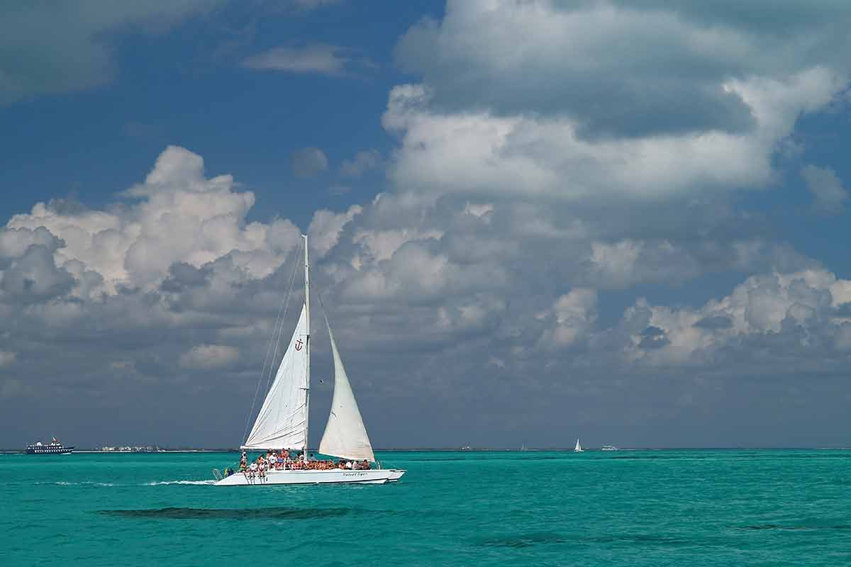 best day trips cancun catamaran on aquamarine water with blue sky