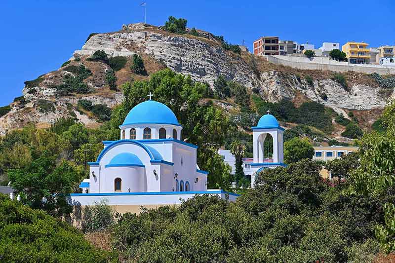 greek chapel at the foot of a hill