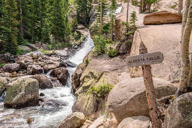 best national parks in colorado waterfall over rocks and sign that says 'Alberta Falls'