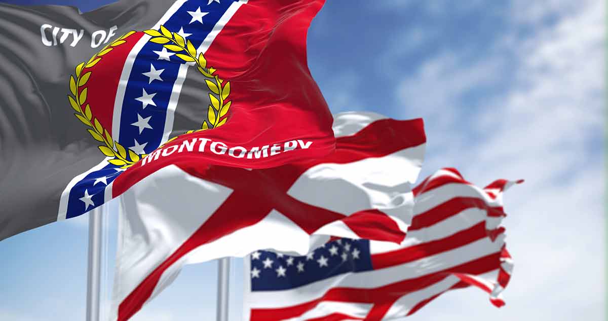 best things to do in Montgomery The flag city of Montgomery waving in the wind with the flags of Alabama state and United States of America.