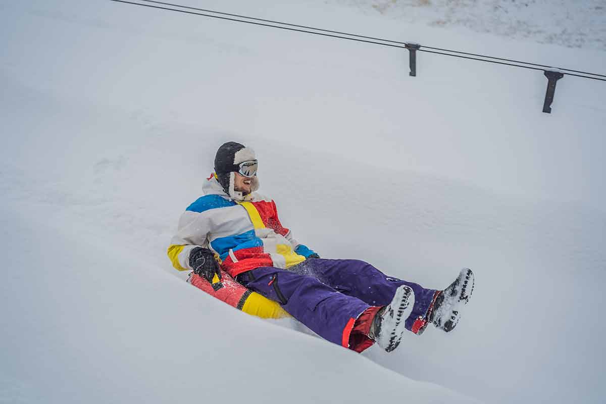 Man Snow Tubing From Hill