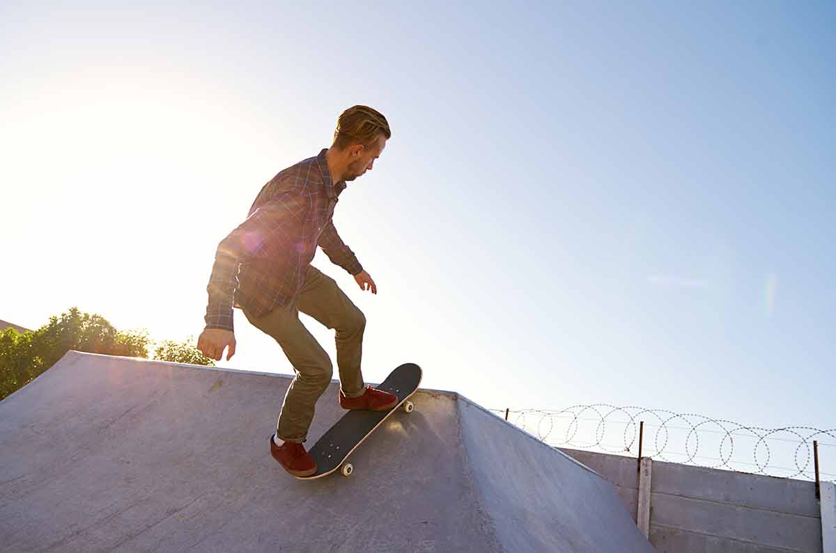 Young Man Doing Tricks On His Skateboard At The Skate Park