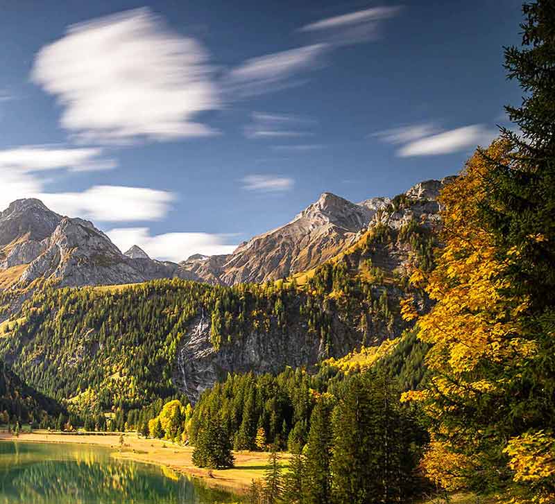 best time of year to visit switzerland autumn trees and mountain background
