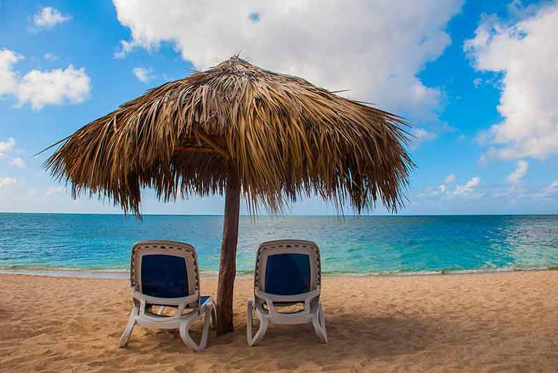 best time to visit cuba weather Ancona Beach thatch umbrella and two beach lounges