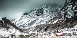 best time to visit fjords norway snow-covered village and mountain backdrop