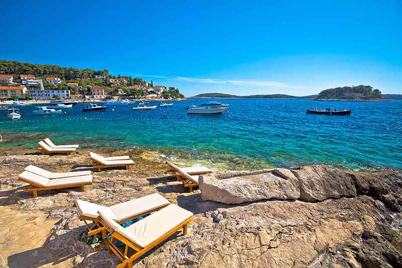 best time to visit hvar croatia lounge chairs on a rocky beach