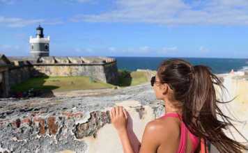 best time to visit puerto rico reddit Puerto Rico travel tourist woman in San Juan, looking down at the fort Castillo San Felipe Del Morro,
