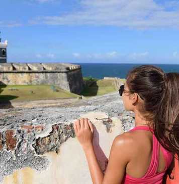 best time to visit puerto rico reddit Puerto Rico travel tourist woman in San Juan, looking down at the fort Castillo San Felipe Del Morro,