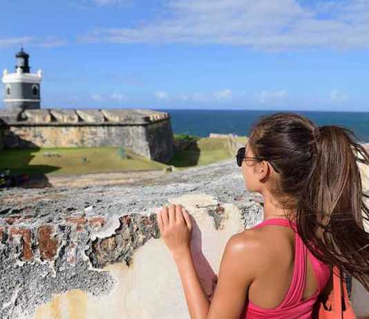 best time to visit puerto rico reddit Puerto Rico travel tourist woman in San Juan, looking down at the fort Castillo San Felipe Del Morro,