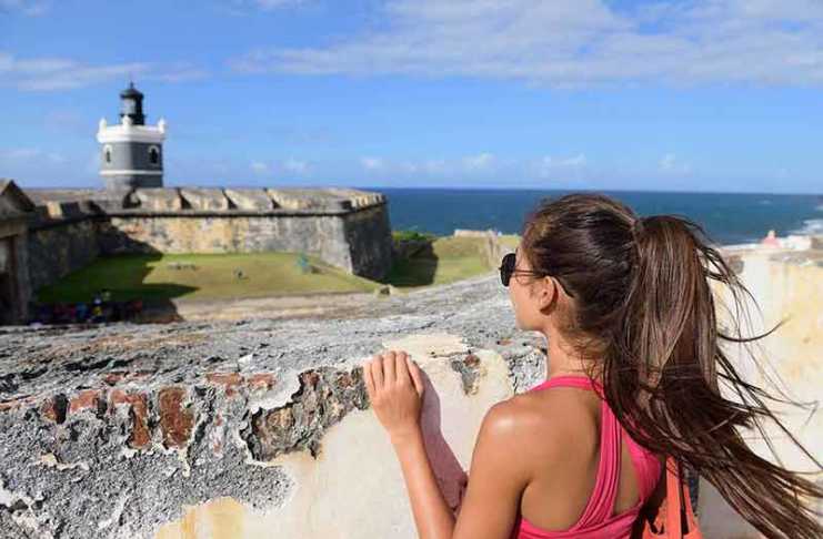 best time to visit puerto rico reddit Puerto Rico travel tourist woman in San Juan, looking down at the fort Castillo San Felipe Del Morro,