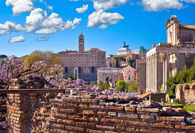 best time to visit rome italy in spring purple flowers at the roman forum