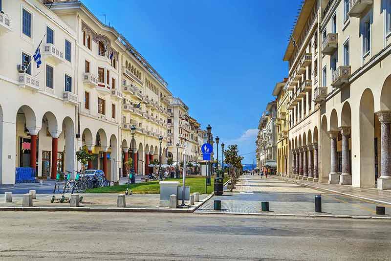 best time to visit santorini greece historic pastel buildings flanking a pedestrian street