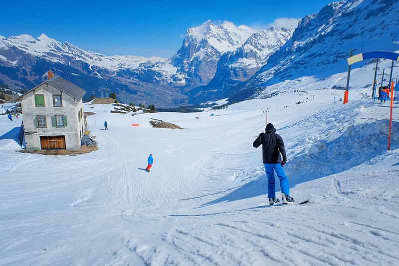 best time to visit switzerland for snow Skier skiing downhill in high mountains Kleine Scheidegg station at Switzerland