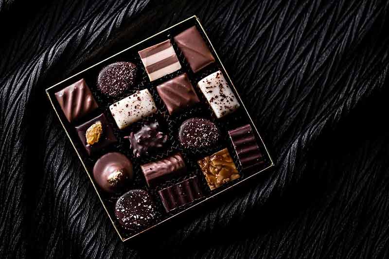 best time to visit switzerland in 2019 Swiss chocolates in gift box, various luxury pralines made of dark and milk organic chocolate in chocolaterie in Switzerland.