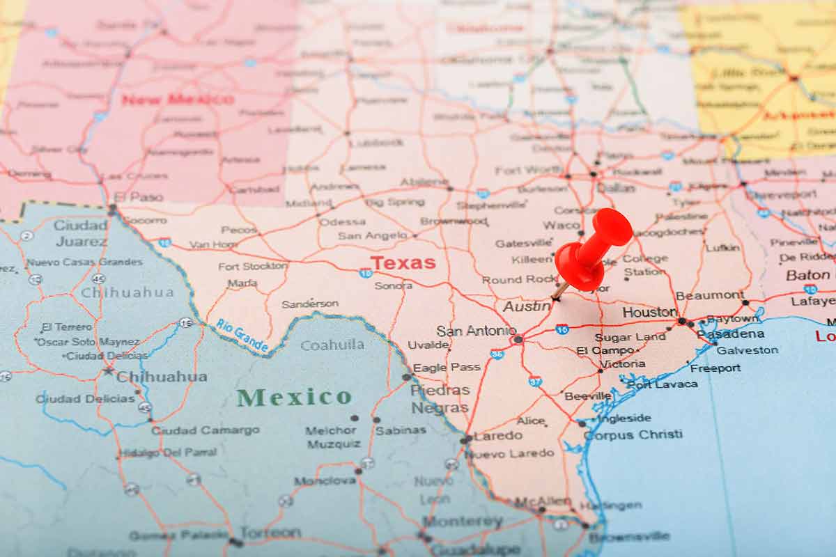 Red clerical needle on a map of USA, Texas and the capital Austin.