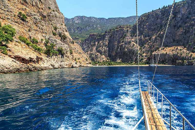 blue lagoon turkey beaches View of Butterfly Valley from a sailing boat with bright sea and high mountains.