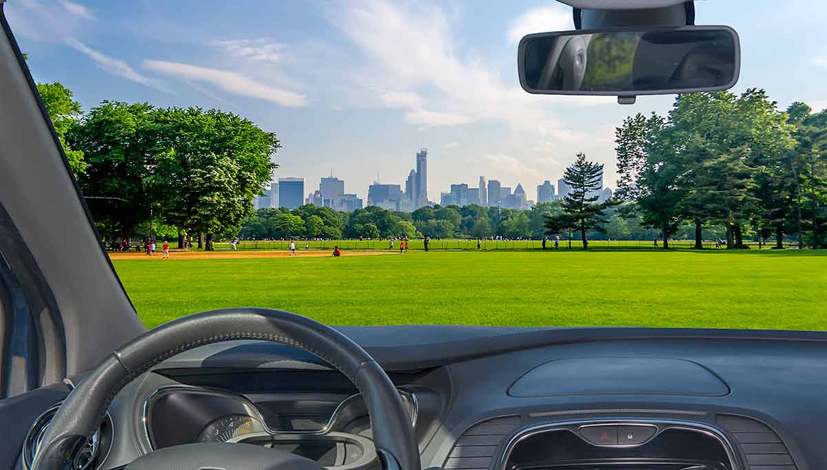 boston to new york central park manhattan Looking through a car windshield with view of Central Park and a beautiful contrast between skyscrapers and buildings, Manhattan, New York City, USA.