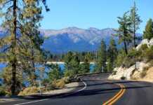 Boston To San Francisco: An Epic Cross-Country American Road Trip winding mountain road, conifer trees around the lake and mountains in the background