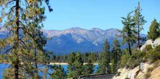 Boston To San Francisco: An Epic Cross-Country American Road Trip winding mountain road, conifer trees around the lake and mountains in the background
