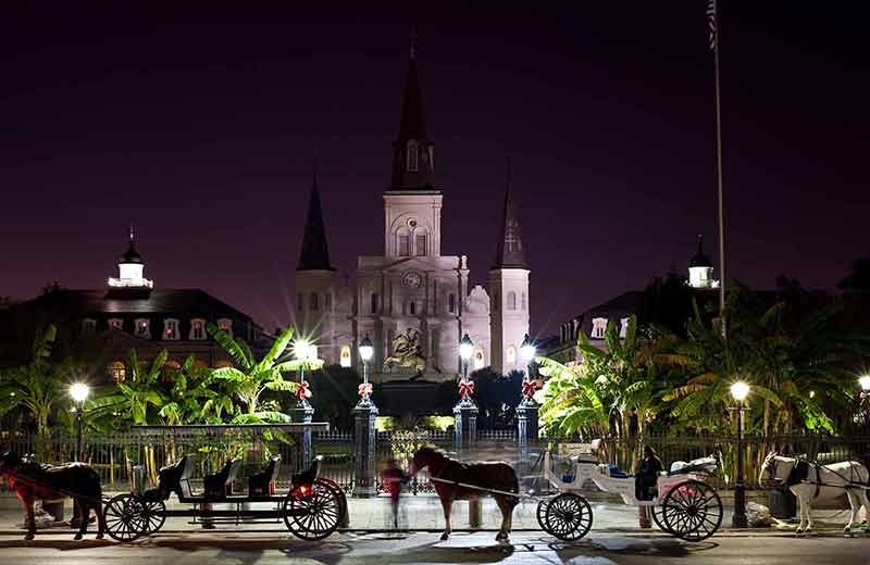 bourbon street, new orleans at night horse carriages lined up