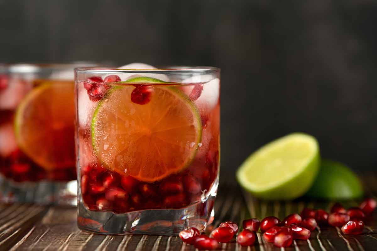 british alcohol drinks pomegranate seeds and lime slices