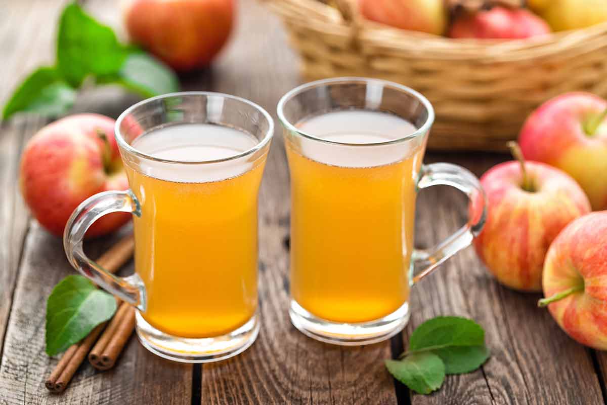british drinks recipes two glass mugs of apple cider and apples in the background