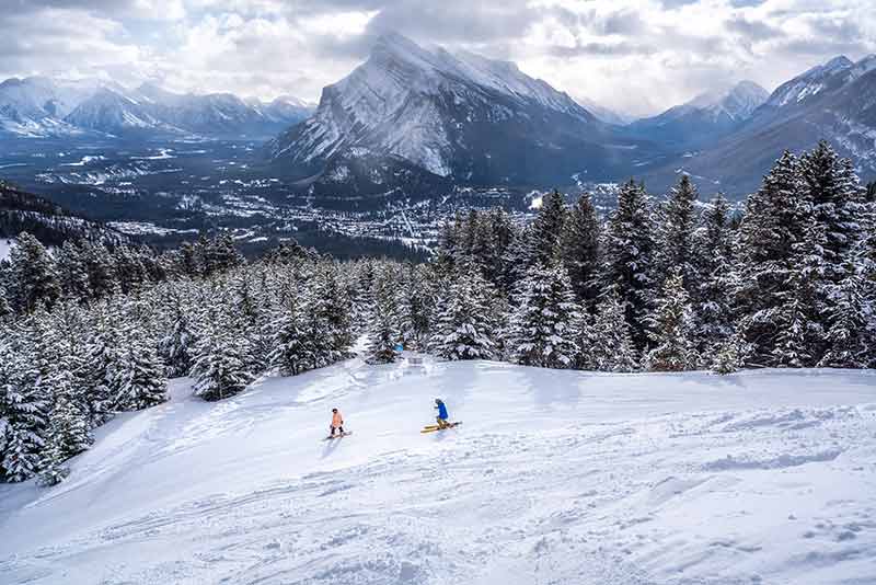 skiers in the rockies in canada in winter