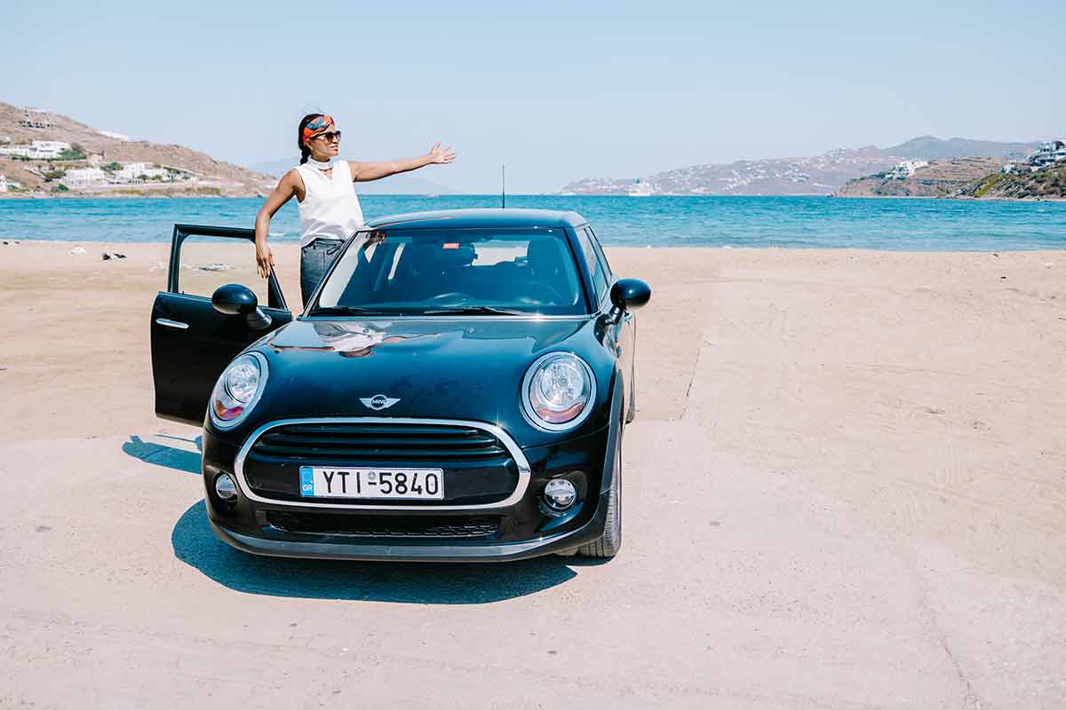 woman in a rental car on a beach in Mykonos