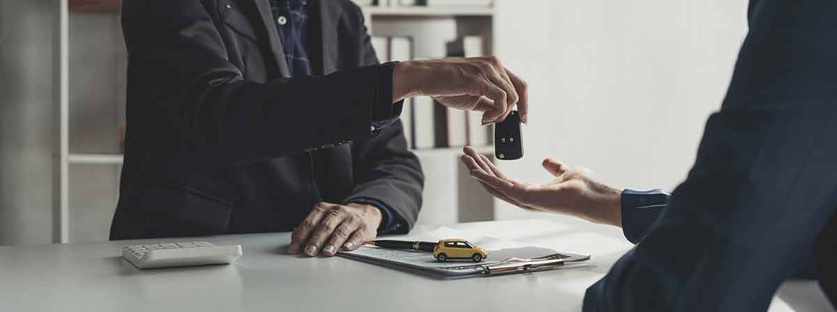 hand passing over car key for car rental contract