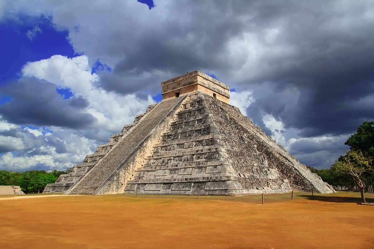chichen itza mayan ruins pyramid against a dramatic sky