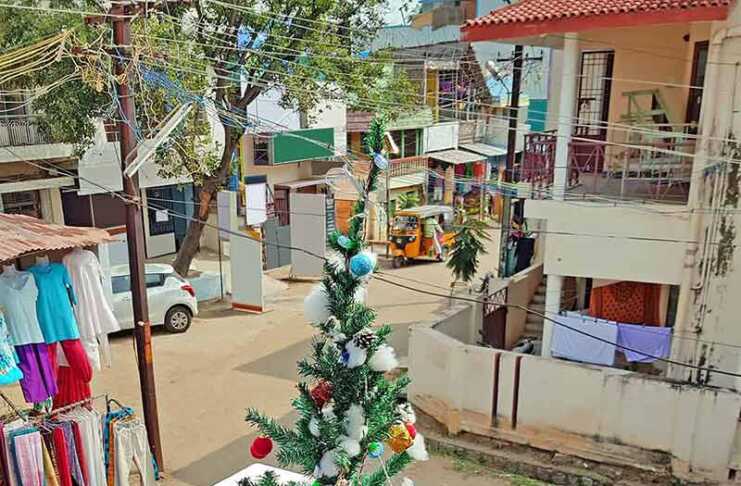 Christmas in India: What the Festive Season Is Really Like woman in red yoga outfit and santa hat meditating on a beach in Kerala during christmas in india