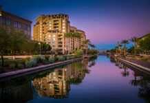 20 Arizona Cities And Towns Beyond The Grand Canyon buildings reflected in the canal in Scottsdale at dusk
