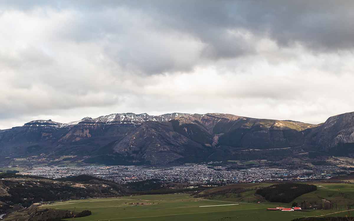 sprawling city of Coyhaique with soaring mountain range in the background