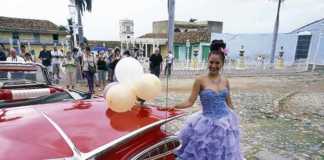 cuba best time of year to visit a vintage red car and woman in a party frock