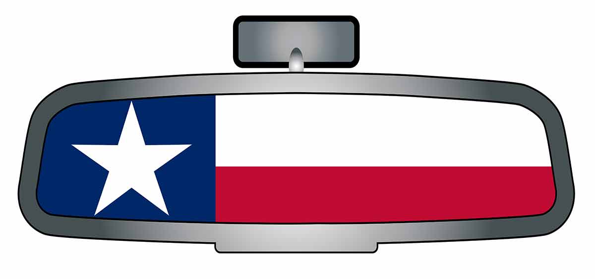 A vehicle rear view mirror with the flag of the state of Texas.