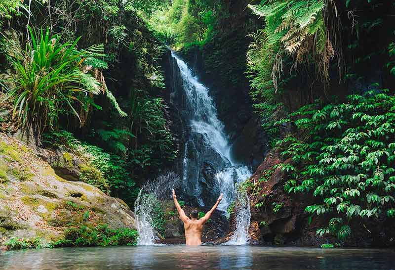 day trips brisbane man having a cool dip in waterfall