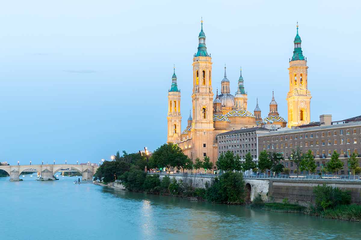 day trips from Madrid to barcelona Our Lady of the Pillar Basilica with Ebro River at dusk