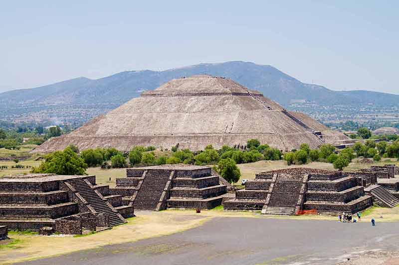day trips from mexico city to teotihuacan huge pyramid with a group of people standing next to it