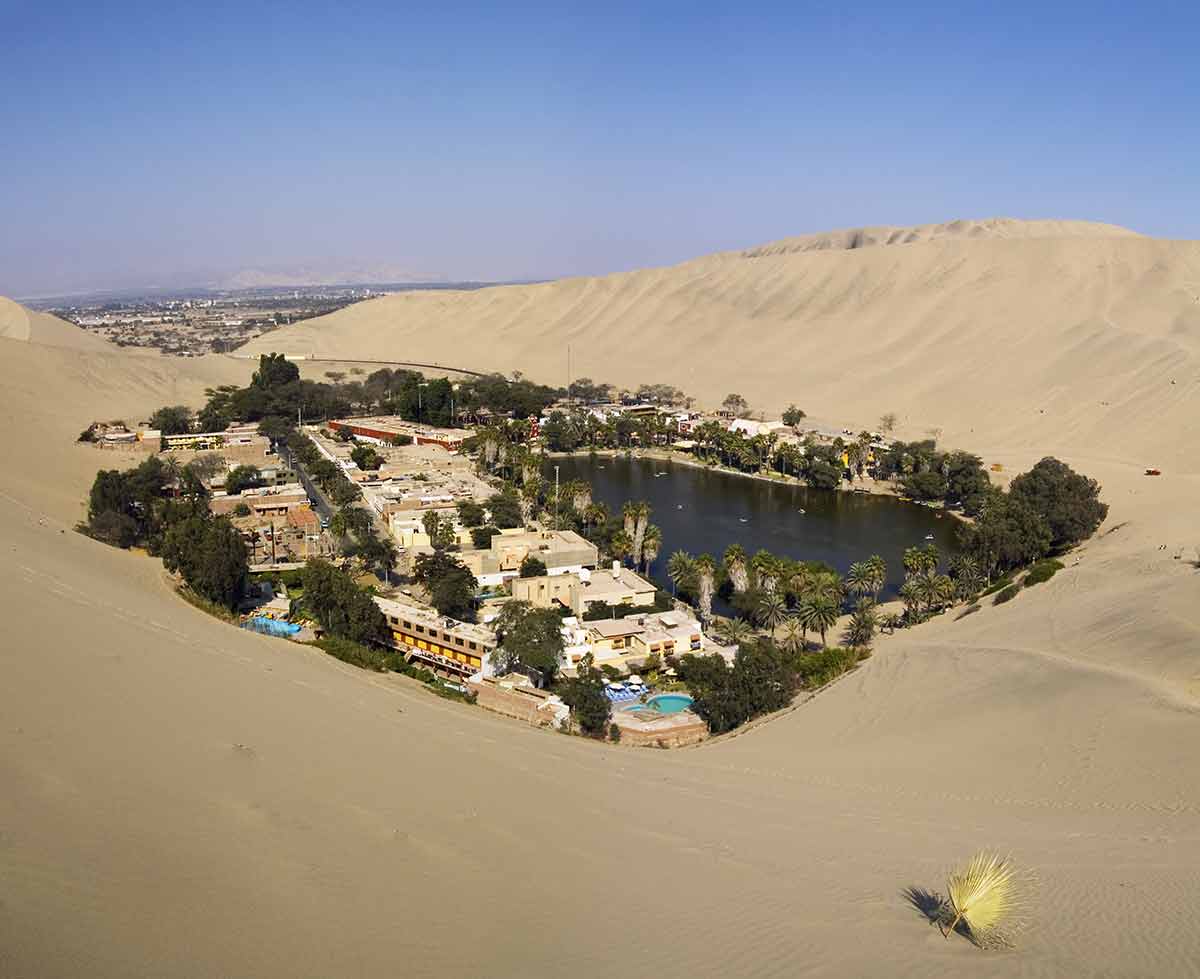 does peru have beaches aerial of oasis surrounded by desert with sandy beach and palm trees