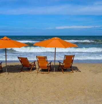 20 Best Things To Do In Duck NC On The Outer Banks orange beach chairs and umbrellas on a beach in duck north carolina