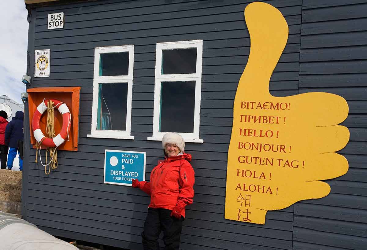 famous antarctica landmarks woman in red jacket in front of Vernadsky Research Station