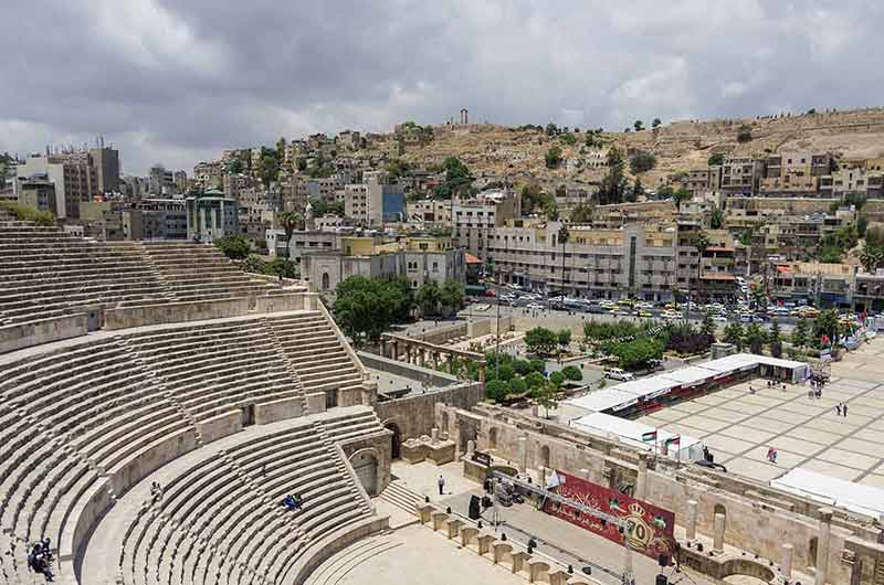 famous landmarks in jordan Roman amphitheatre in downtown with Amman cityscape and citadel hill at background