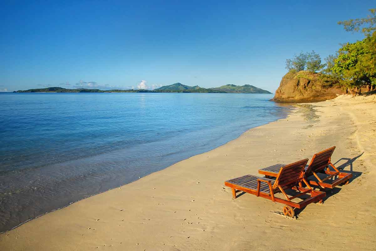 fiji beaches nacula island two timber lounge chairs on the beach