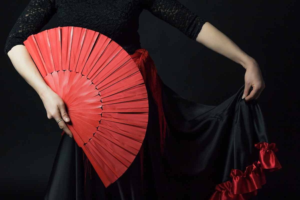 flamenco night at tablao cordobes barcelona photo of Flamenco Dancer holding red fan and her skirt.