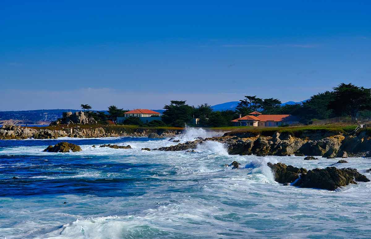 flights from san francisco to san diego Crashing Surf in Monterey with houses.
