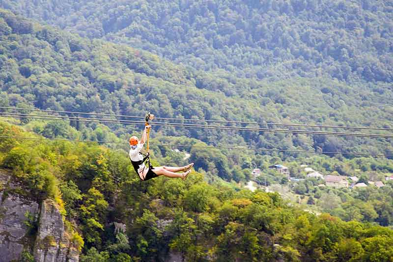 a person ziplining over the landscape